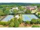 This aerial view reveals immaculately maintained tennis courts, a pavilion, and lush landscaping within a beautiful community at 1223 Gathering Oaks Se Ct, Mableton, GA 30126