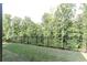 Fenced backyard with lush green lawn, mature trees, and a tranquil setting at 330 Carriage Glen Ln, Woodstock, GA 30188