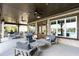 Spacious covered patio with comfortable seating, ceiling fans, and views of the backyard and pool at 330 Carriage Glen Ln, Woodstock, GA 30188