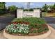 Elegant community entrance featuring lush landscaping, beautiful flower beds, and stone signage at 330 Carriage Glen Ln, Woodstock, GA 30188