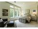 A serene primary bedroom boasts natural light, neutral tones, and an inviting seating area at 330 Carriage Glen Ln, Woodstock, GA 30188