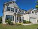 Charming two-story home featuring a white brick facade, black shutters, covered entryway, and an attached two-car garage at 3332 Grace Farm Ln, Buford, GA 30519