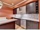 Finished basement with bar featuring dark cabinets, light countertops, backsplash, and stainless steel appliances at 12130 Helleri Holw, Alpharetta, GA 30005