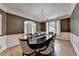 Well-lit dining area featuring an elegant chandelier, wainscoting, and hardwood floors at 12130 Helleri Holw, Alpharetta, GA 30005