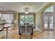 Elegant dining room with a black glass table, views of the backyard, and access to the outdoor patio at 12130 Helleri Holw, Alpharetta, GA 30005