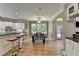 Open-concept kitchen and dining area with stainless appliances, a bar, and backyard views at 12130 Helleri Holw, Alpharetta, GA 30005