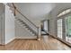 Bright foyer with hardwood floors, staircase, and double doors that offer natural light and views of the outdoor space at 12130 Helleri Holw, Alpharetta, GA 30005