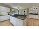 Kitchen island featuring granite countertops, cooktop, white cabinets and stainless appliances at 12130 Helleri Holw, Alpharetta, GA 30005