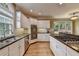 Well-equipped kitchen features stainless appliances, granite countertops, and an island with a cooktop at 12130 Helleri Holw, Alpharetta, GA 30005
