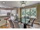 Bright kitchen with white cabinets, stainless steel appliances, and a dining area with views of the outdoors at 12130 Helleri Holw, Alpharetta, GA 30005
