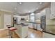 Modern kitchen equipped with stainless steel appliances, white cabinetry, and an island with bar seating at 12130 Helleri Holw, Alpharetta, GA 30005