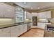 Kitchen with white cabinets, stainless appliances, granite counters and large window at 12130 Helleri Holw, Alpharetta, GA 30005