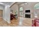 Open living room with hardwood floors, fireplace, high ceilings, and arched windows at 12130 Helleri Holw, Alpharetta, GA 30005