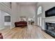 Bright living room featuring fireplace, tall windows, hardwood floors, and open floor plan at 12130 Helleri Holw, Alpharetta, GA 30005
