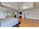Bright main bedroom with hardwood floors, sitting area with fireplace and a tray ceiling at 12130 Helleri Holw, Alpharetta, GA 30005