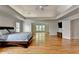 A well-lit main bedroom has hardwood floors, neutral colors, and open living space with fireplace at 12130 Helleri Holw, Alpharetta, GA 30005