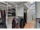 Walk-in closet has wood floors, built-in shelves, drawers, and hanging rods at 12130 Helleri Holw, Alpharetta, GA 30005