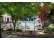Community pool surrounded by lush trees, lounge chairs, and a secure black fence at 1668 Sabastian Ne Pt, Atlanta, GA 30329