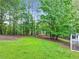 Expansive backyard view showcasing a lush lawn, mature trees, and a charming fire pit area at 394 Thornbrooke Dr, Hiram, GA 30141