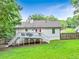 Backyard view of a home with a deck, lush green lawn, and a fenced area at 394 Thornbrooke Dr, Hiram, GA 30141