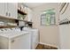 Functional laundry room with washer, dryer, built-in storage, and a window for natural light at 394 Thornbrooke Dr, Hiram, GA 30141