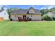 Home's back exterior featuring a wooden deck overlooking a large, green lawn at 525 Hunnicutt Se Rd, Mableton, GA 30126
