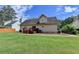 View of the home's rear, showcasing a wooden deck and a well-maintained lawn at 525 Hunnicutt Se Rd, Mableton, GA 30126
