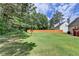 Large grassy backyard bordered by a wooden fence and mature trees at 525 Hunnicutt Se Rd, Mableton, GA 30126