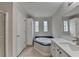 Bright bathroom featuring a soaking tub with blue trim and decorative windows at 525 Hunnicutt Se Rd, Mableton, GA 30126