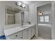 Bathroom view featuring a white vanity and mirror leading to bedroom with ceiling fan at 525 Hunnicutt Se Rd, Mableton, GA 30126