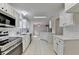 Bright kitchen features white cabinetry, stainless appliances, tile backsplash and floors, and open layout at 525 Hunnicutt Se Rd, Mableton, GA 30126
