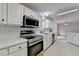 Bright kitchen features white cabinets, stainless steel appliances, subway tile backsplash, and tile flooring at 525 Hunnicutt Se Rd, Mableton, GA 30126