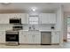 Bright kitchen featuring white cabinets, subway tile backsplash, stainless appliances, and door to deck at 525 Hunnicutt Se Rd, Mableton, GA 30126