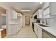 A well-lit kitchen with stainless steel appliances, white cabinetry, subway tile backsplash and laundry area at 525 Hunnicutt Se Rd, Mableton, GA 30126