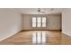Large living room boasting hardwood floors, three windows, and a neutral color palette at 525 Hunnicutt Se Rd, Mableton, GA 30126