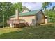 Backyard featuring a deck, lush grass, mature trees, and a partial view of the surrounding natural landscape at 165 Country Mill Ln, Stockbridge, GA 30281