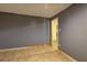 Basement room has tiled floor, gray walls, and doorway to another room at 165 Country Mill Ln, Stockbridge, GA 30281
