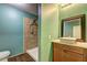 Bathroom showcasing a walk-in shower, a vanity with a vessel sink, a modern faucet, and wood look tile floor at 165 Country Mill Ln, Stockbridge, GA 30281
