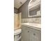 Modern bathroom with gray vanity, bright white sink, and marble-look backsplash at 165 Country Mill Ln, Stockbridge, GA 30281