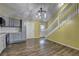 Kitchen with modern lighting and adjoining staircase, featuring hardwood floors at 165 Country Mill Ln, Stockbridge, GA 30281