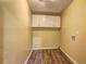 A view of the laundry room with wood floors and white cabinets at 165 Country Mill Ln, Stockbridge, GA 30281