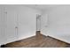 Empty room features hardwood floors, freshly painted white walls, and multiple doorways at 2222 Beecher Sw Cir, Atlanta, GA 30311