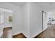 Bright hallway featuring hardwood floors, white walls, and barn door entry to main bedroom at 2222 Beecher Sw Cir, Atlanta, GA 30311