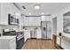 Bright kitchen featuring white cabinets, stainless steel appliances, and wood floors at 2222 Beecher Sw Cir, Atlanta, GA 30311