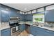 Bright kitchen with stainless steel appliances, granite countertops, and ample cabinet space at 6744 Rockbridge Rd, Stone Mountain, GA 30087