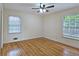 Cozy bedroom featuring hardwood floors, two windows, and a ceiling fan at 2543 Asbury Court Ct, Decatur, GA 30033