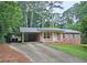 Charming one-story brick home with a carport and a well-manicured front yard and concrete driveway at 2543 Asbury Court Ct, Decatur, GA 30033