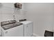 Functional laundry room includes modern washer and dryer with storage shelf at 2766 Aralynn Way, College Park, GA 30337