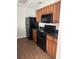 Kitchen with wood cabinets, dark countertops, black appliances including range, microwave, and refrigerator at 8430 Carlington Ln, Jonesboro, GA 30236