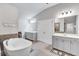 Bright bathroom featuring double vanities, a soaking tub, and tile floors, offering a luxurious and functional design at 109 Jodi Pl, Locust Grove, GA 30248